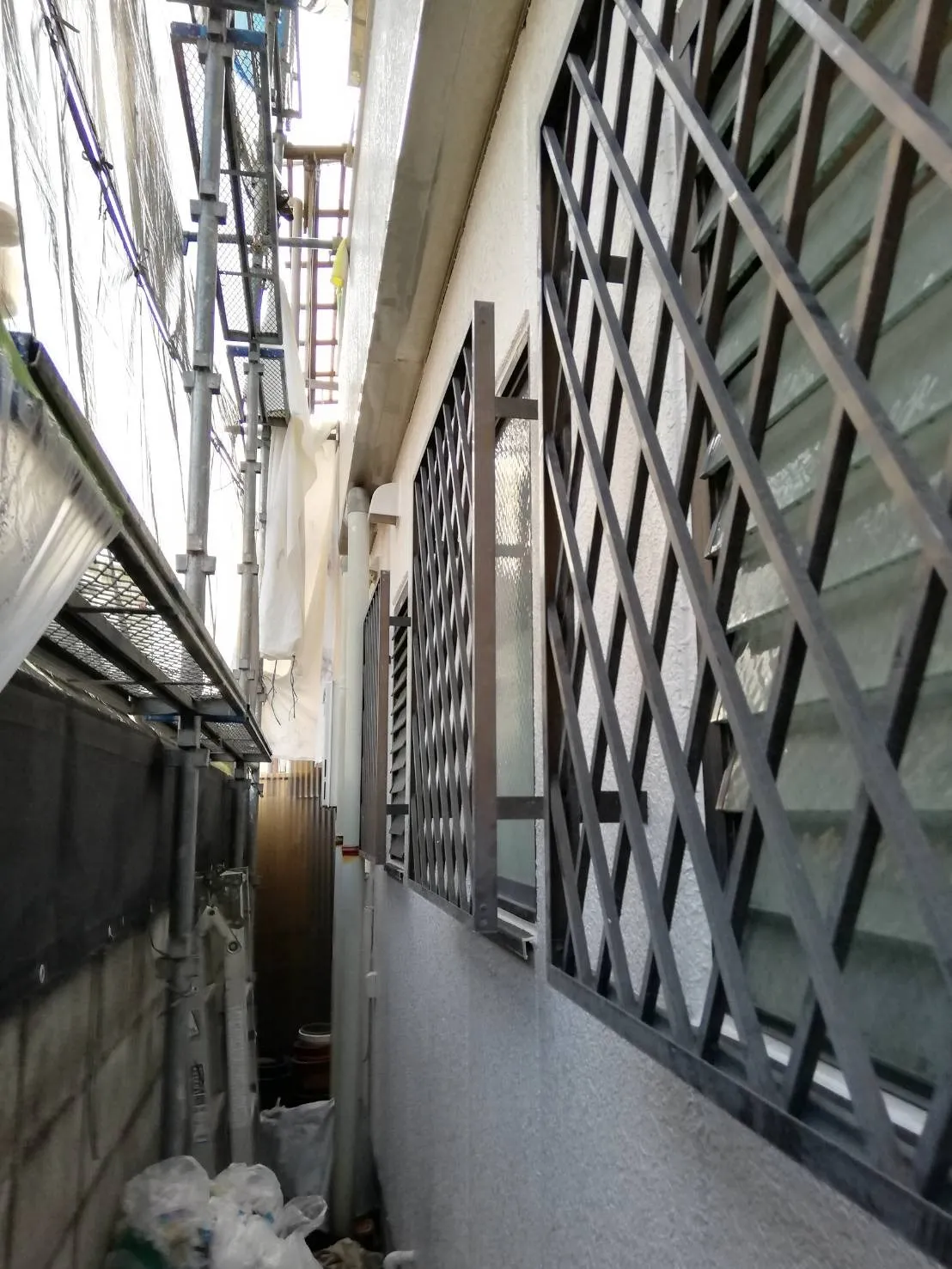 大阪府吹田市で外壁補修､外壁部分塗装､屋根補修､屋根塗装､ベランダ簡易防水､シーリング工事中､シーリング工事が完了したので窓格子を付けました